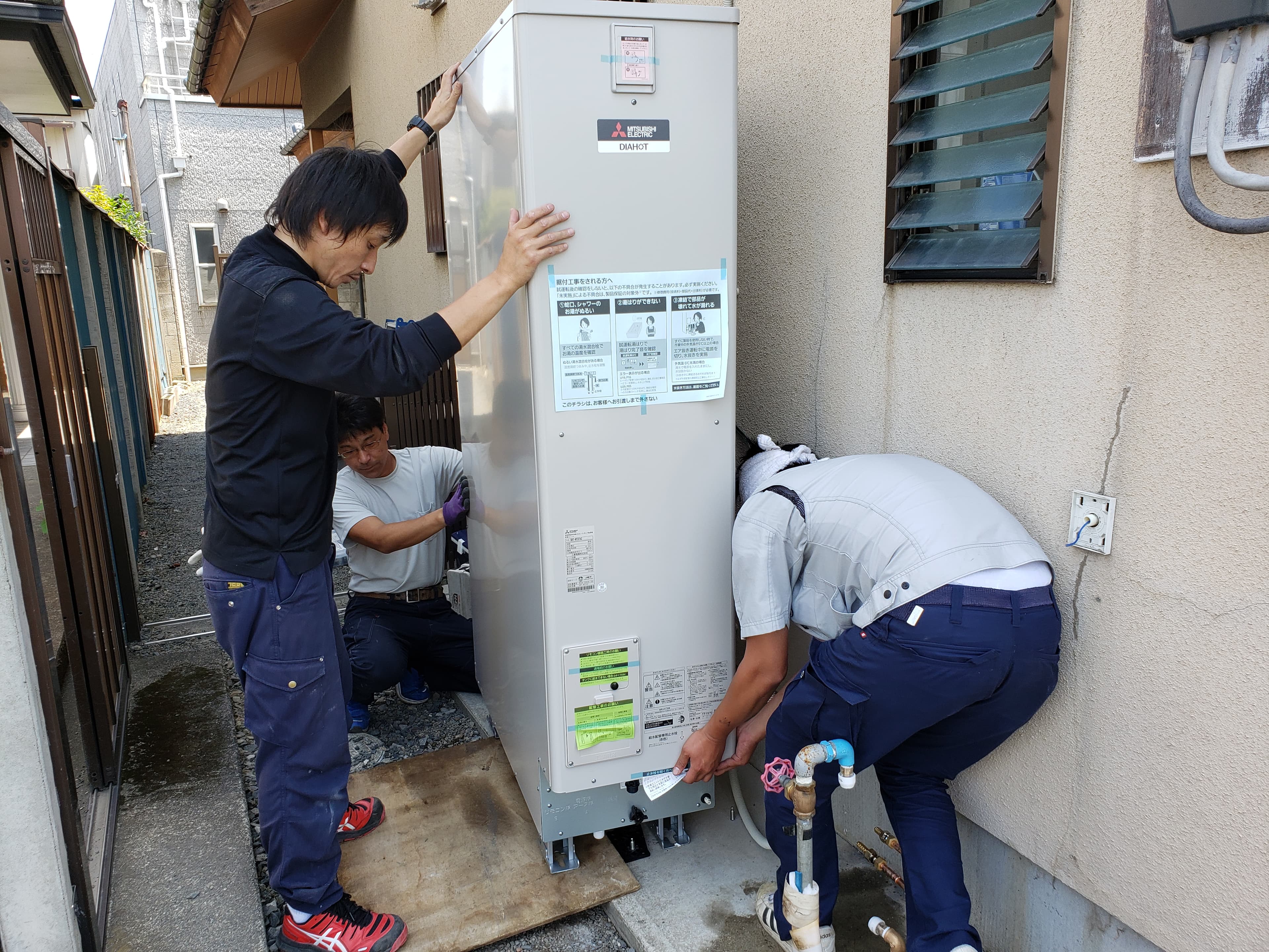 エコキュート設置を確認する作業員